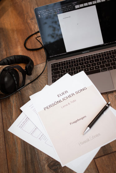 live-musik-zur-hochzeit-persoenlicher-song-(c)studiolaecheln Flatlay: Laptop, Kopfhörer und Fragebogen zu einem persönlichen Song, welchen man zur Hochzeit verschenken könnte.