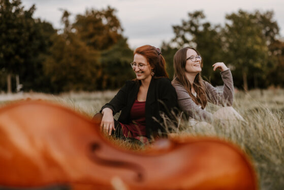 Hannah & Lea Hannah Stienen steht mit ihrer Gitarre in einer Kirche und singt.